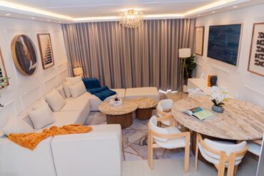 Sandton apartment open-plan living and dining area with a sectional sofa and round dining table
